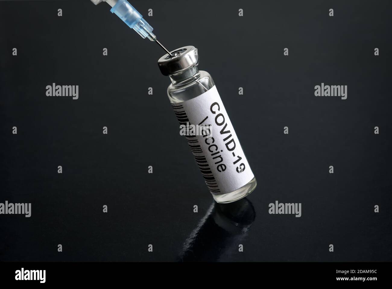 Vaccino COVID-19 su banco nero, siringa e flacone con vaccino per la cura del coronavirus. Concetto di ricerca, trattamento, iniezione, shot e virus corona Foto Stock