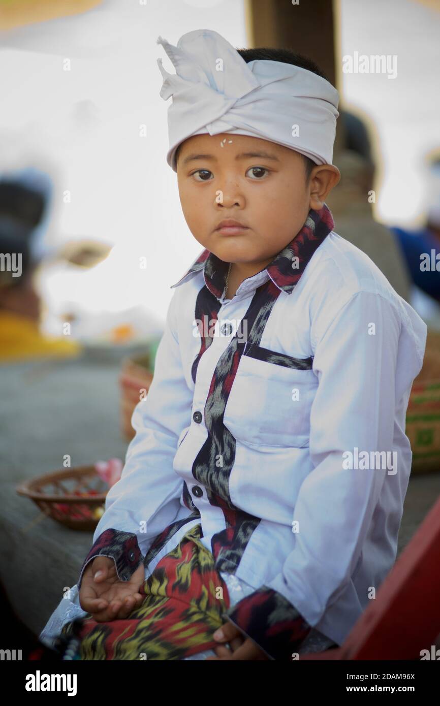 Ragazzo balinese in abbigliamento tradizionale che frequenta un tempio locale per l'inizio del festival di Galungan. Vicino a Ubud, Bali, Indonesia Foto Stock