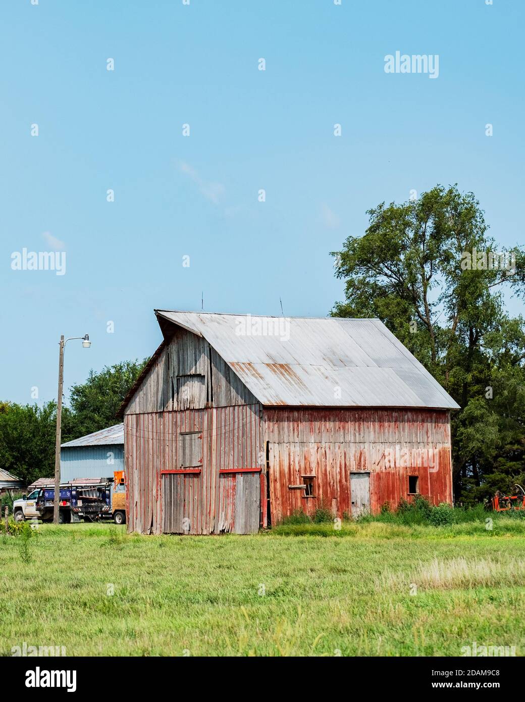 Vecchio fienile di legno rosso sbiadito in Kansas rurale, Stati Uniti. Foto Stock