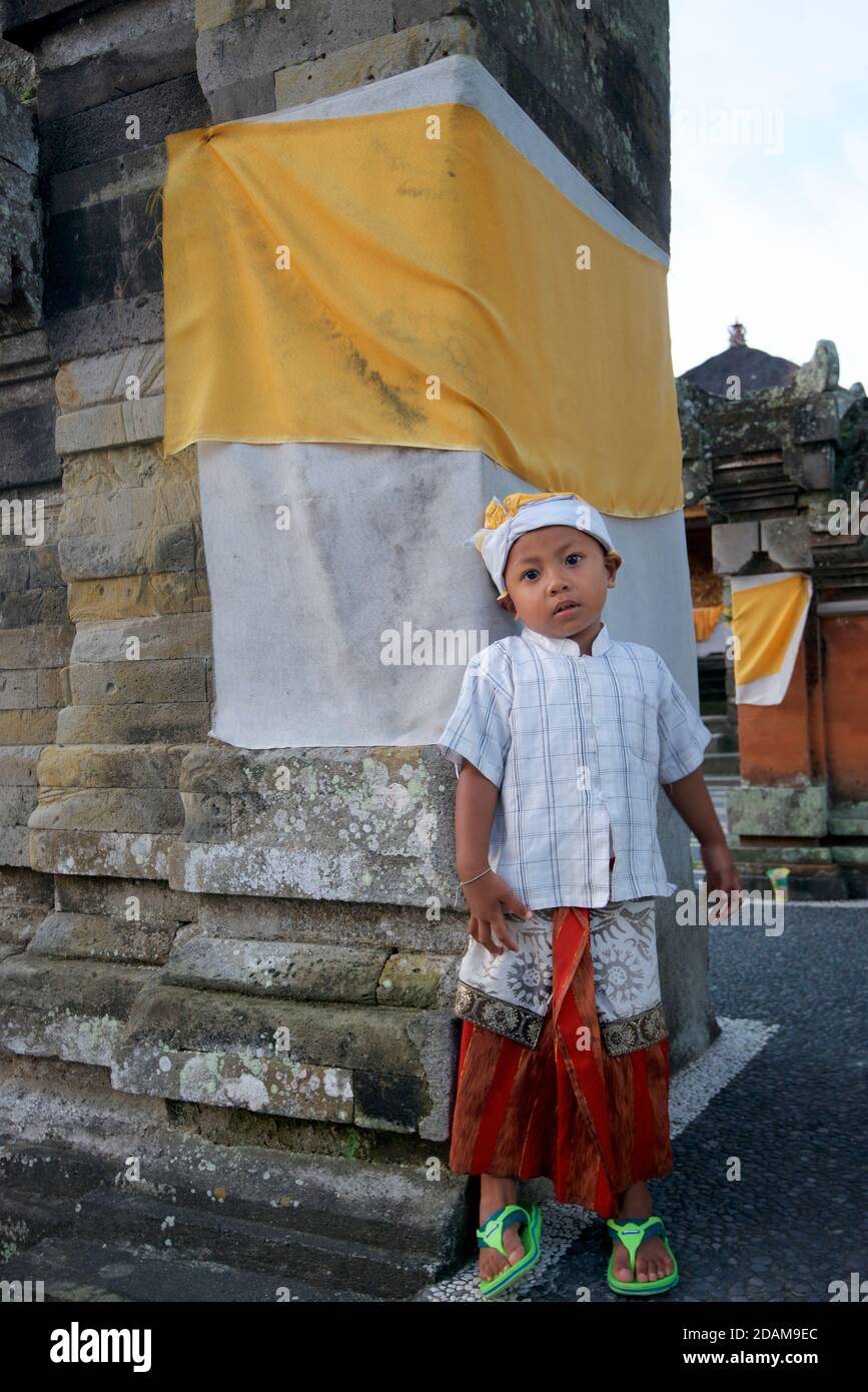 Ragazzo bainese in abbigliamento tradizionale all'ingresso di un tempio balinese, vicino a Ubud, Bali, Indonesia Foto Stock
