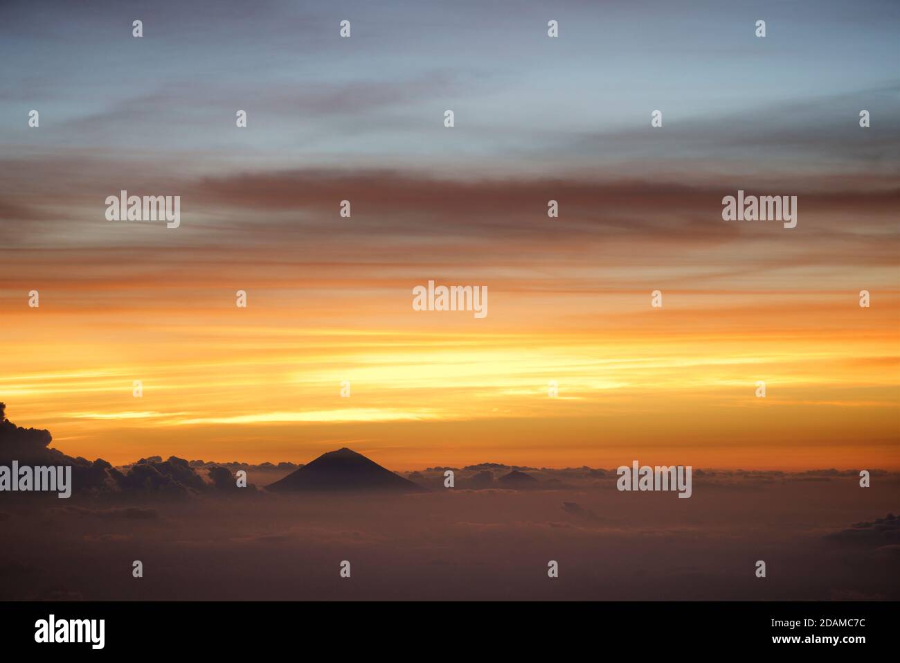 Monte Agung su Bali visto dal bordo del cratere del vulcano Rinjani, Lombok, Indonesia. Dawn Foto Stock