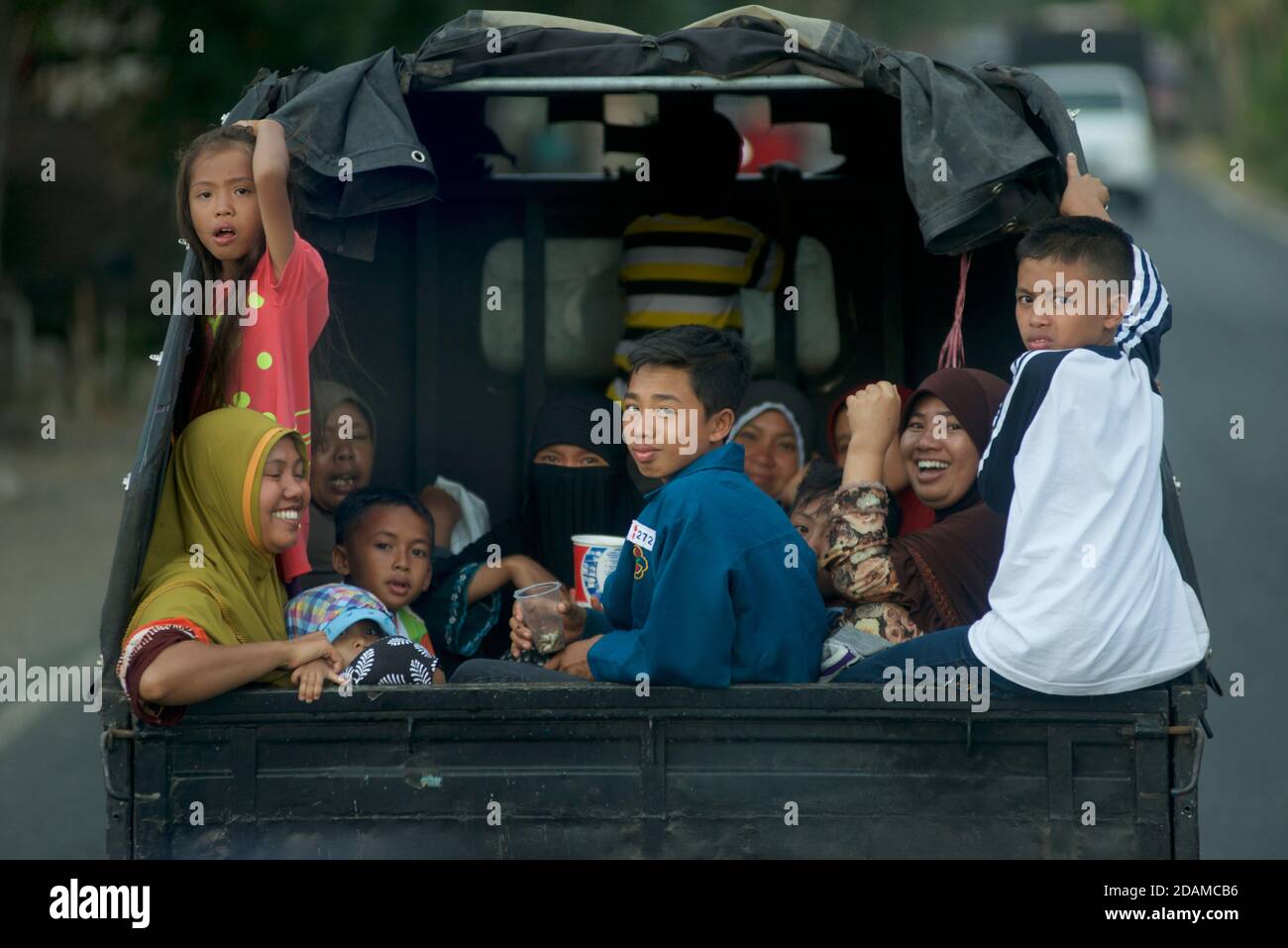 Indonesiani che viaggiano sul retro di un pick-up, Lombok, Indonesia Foto Stock