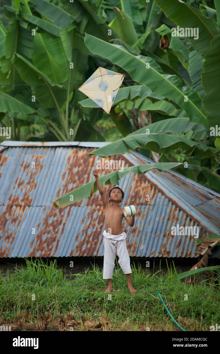 Candida fotografia di un ragazzo indonesiano che vola un aquilone, Lombok, Indonesia Foto Stock
