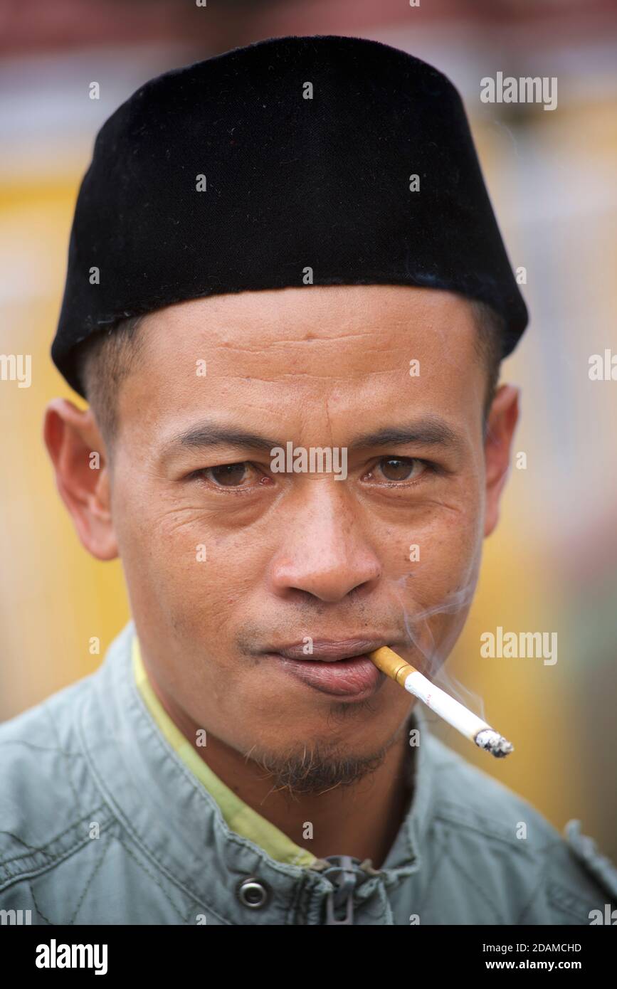 Uomo indonesiano con caratteristico cappello di tipo songkok. Il songkok o peci o kopiah è un cappuccio ampiamente indossato in se Asia tra gli uomini musulmani. Pringgasela, Lombok, Indonesia. Foto Stock