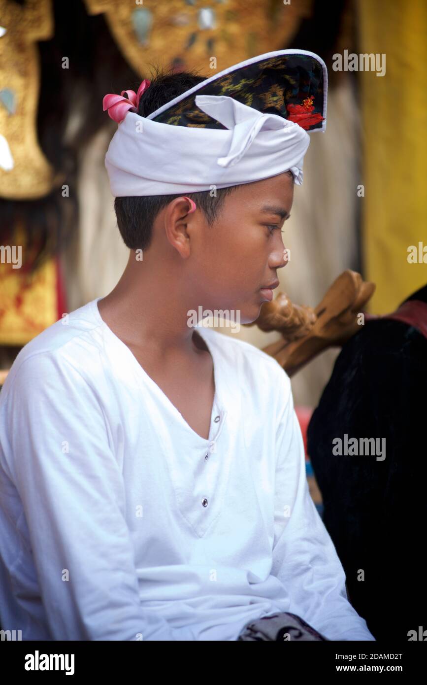 Ragazzo balinese con abbigliamento bianco festivo al tempio Sakenan per Galungan. Pregare. Bali, Indonesia. Foto Stock