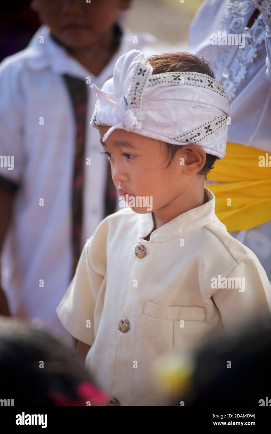 Ragazzo balinese in abbigliamento festivo al tempio Sakenan, Bali, Indonesia per le feste galungane. Foto Stock