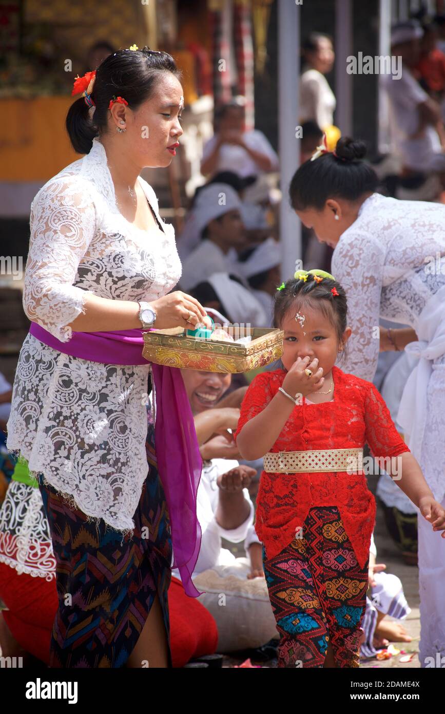 I tempiatori balinesi in abito festivo per le celebrazioni di Galungan, tempio Sakenan, Bali, Indonesia. Foto Stock