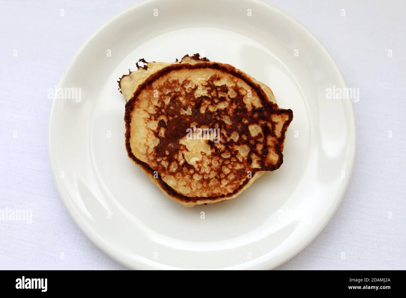 Piatto bianco con pancake su un tavolo Foto Stock