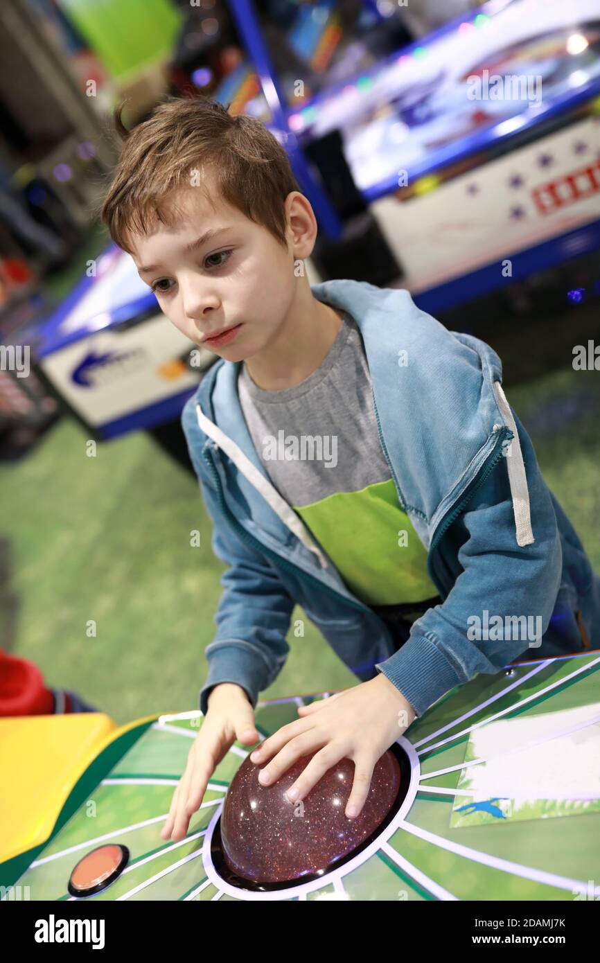 Bambini che giocano a una partita arcade nel parco divertimenti Foto Stock