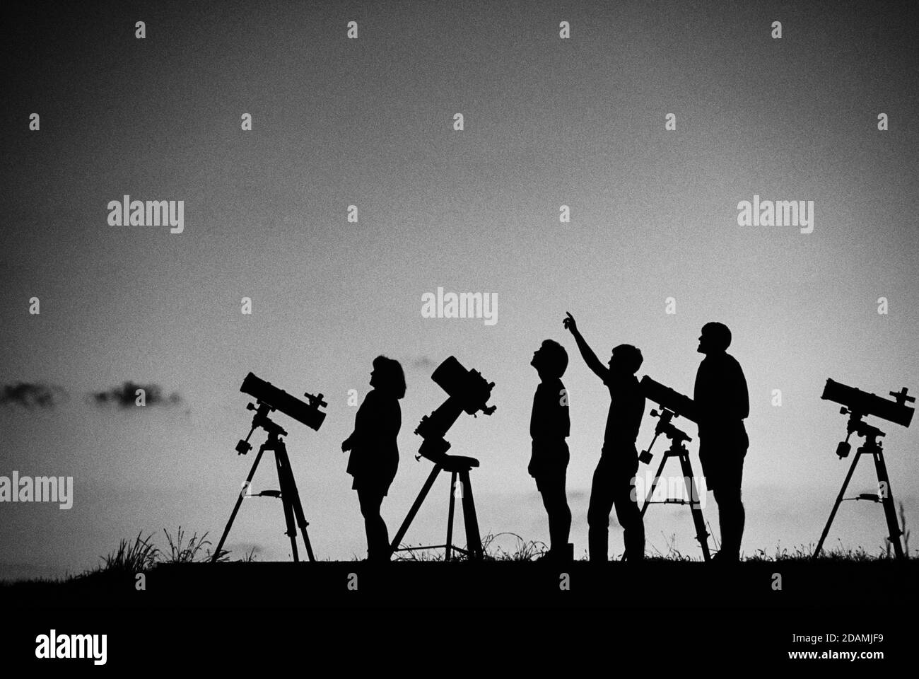 Studenti di astronomia amatoriali su una collina al tramonto. Foto Stock