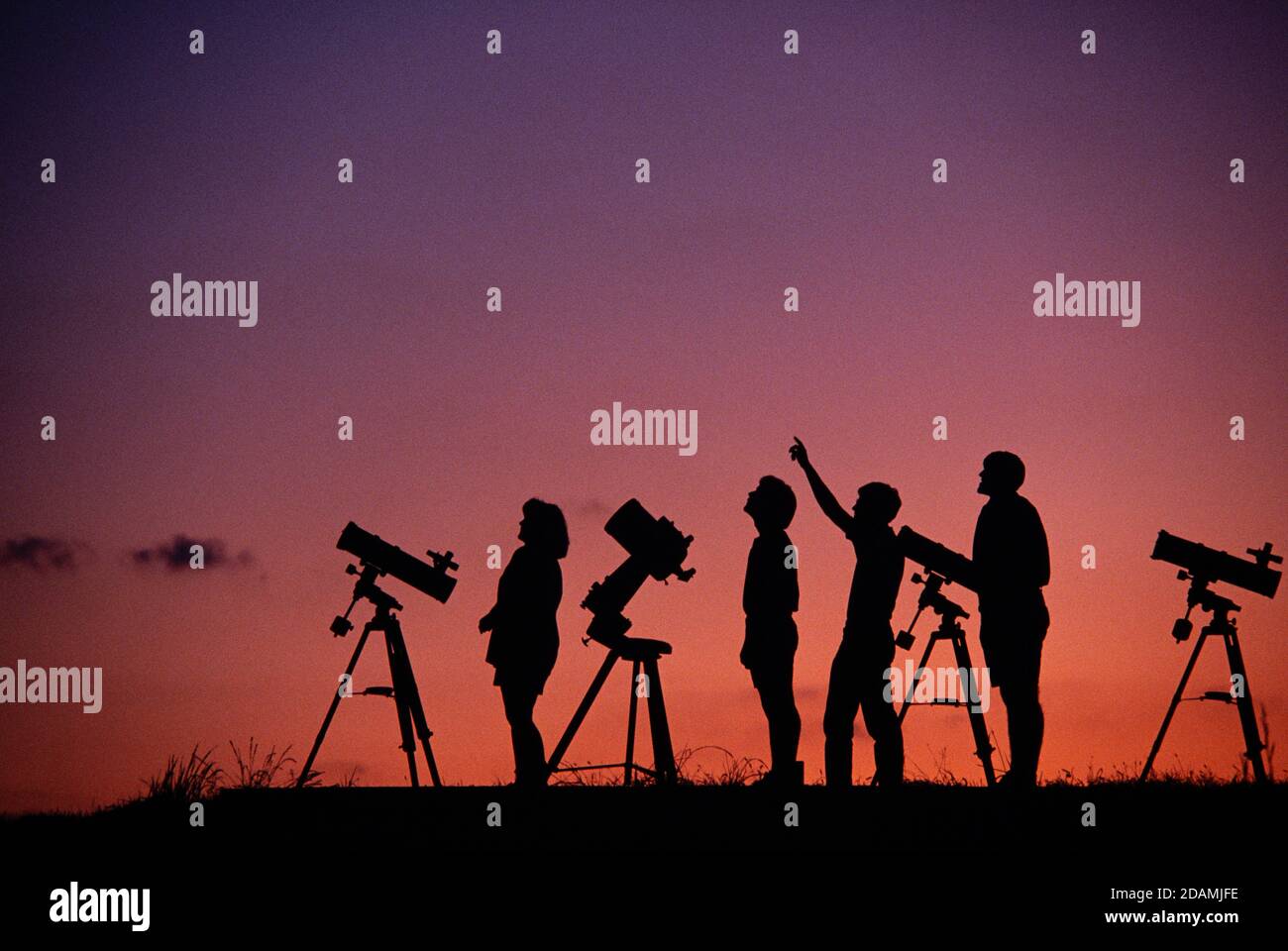 Studenti di astronomia amatoriali su una collina al tramonto. Foto Stock