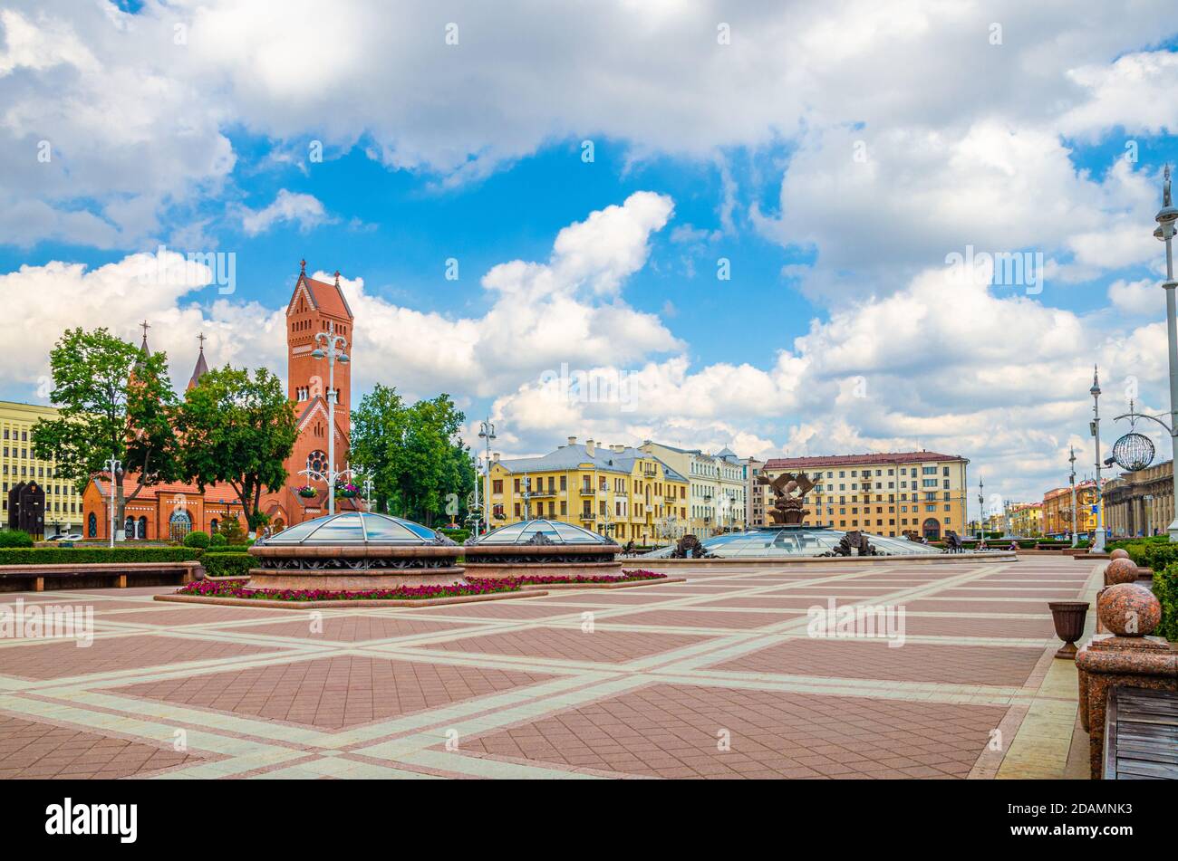 Piazza dell'Indipendenza nel centro di Minsk con la chiesa cattolica romana dei Santi Simone e Helena o la chiesa rossa e l'edificio dell'hotel di Minsk, clo bianco cielo blu Foto Stock