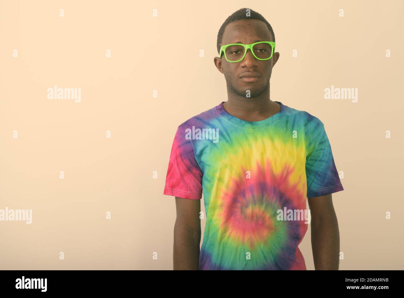 Studio di un giovane uomo africano nero che indossa una camicia colorata e occhiali verdi su sfondo bianco Foto Stock