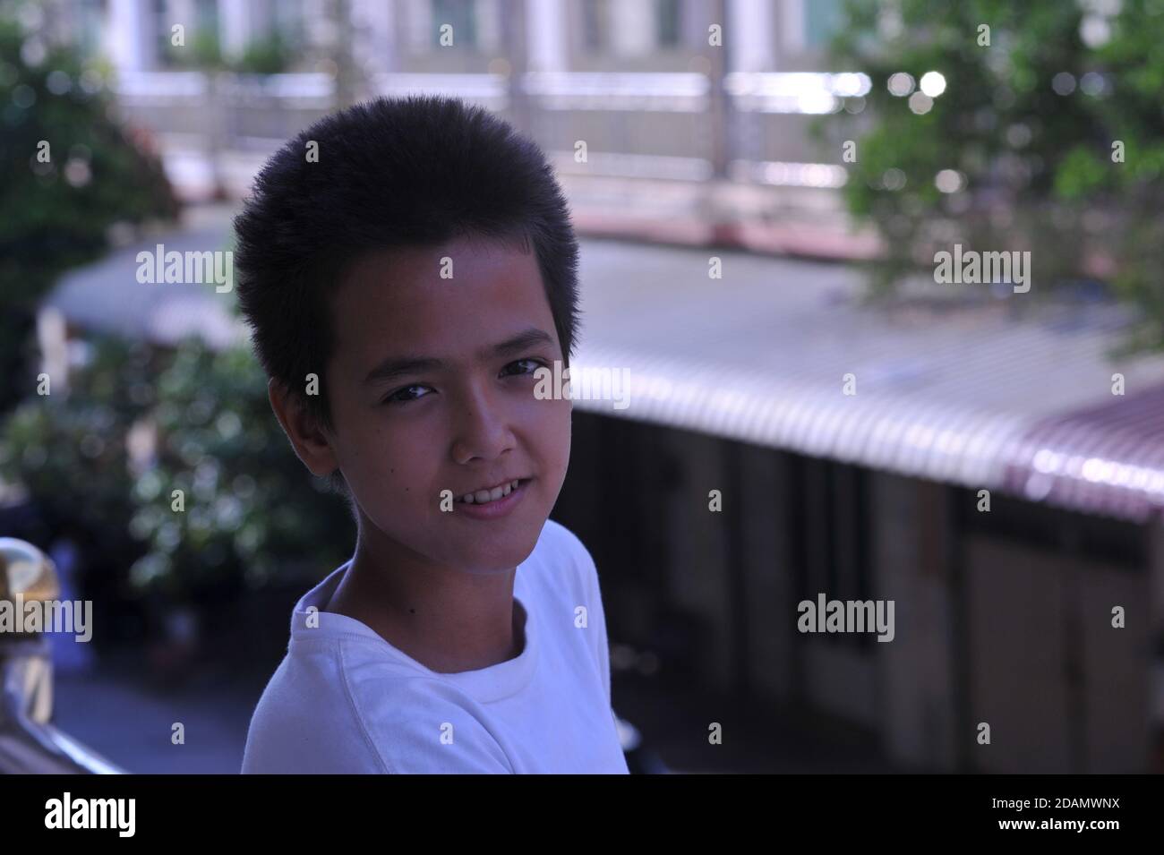 Durante un parziale blocco imposto dal governo cambogiano, un ragazzo di 13 anni di razza mista (cambogiano - americano) nei sobborghi, passa il suo tempo su un balcone. Steung Meanchey, Phnom Penh, Cambogia. © Kraig Lieb Foto Stock