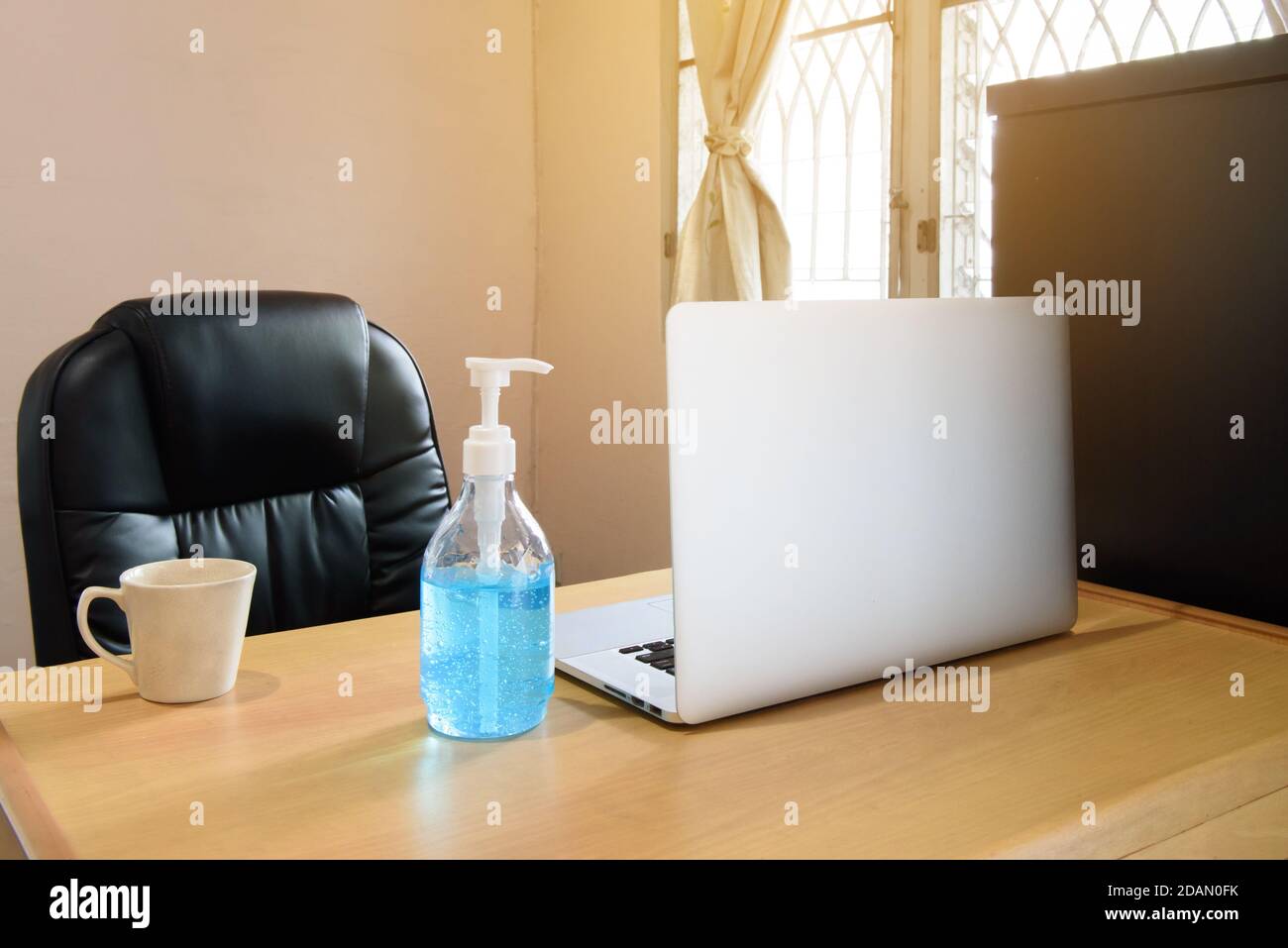 Spazio di lavoro a casa con computer portatile, tazza di caffè e alcoho handgel, idea per evento di crisi coronavirus, covid19 Foto Stock