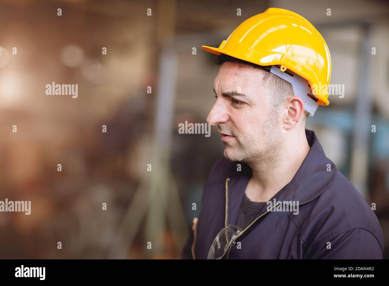 Europeo russo profilo operaio immagine bello Signore look indossare casco tuta di sicurezza lavoro in fabbrica. Foto Stock