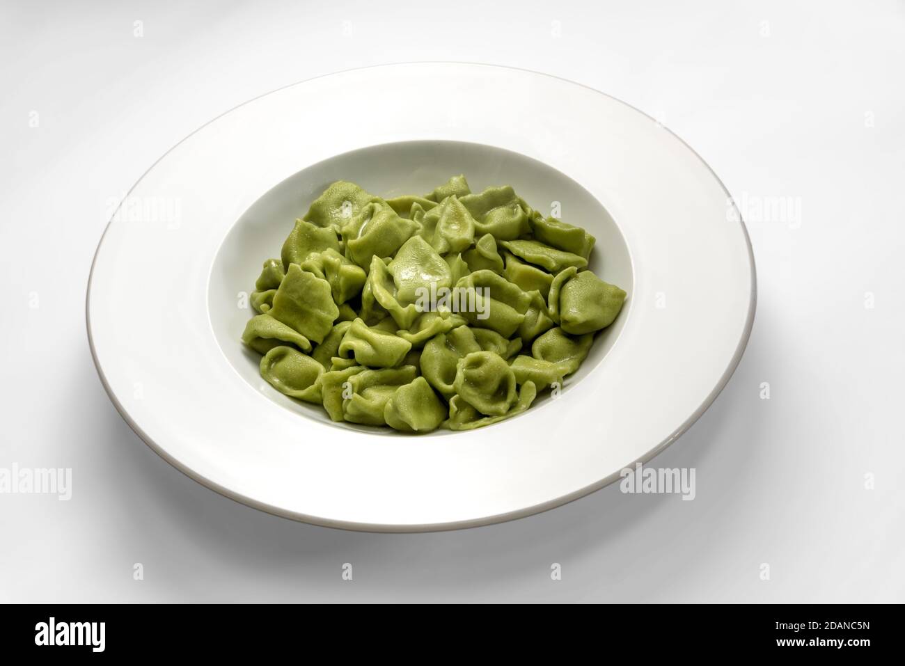 ravioli verdi del plin, pasta delle langhe italia, a base di pasta all'uovo e spinaci su fondo bianco Foto Stock