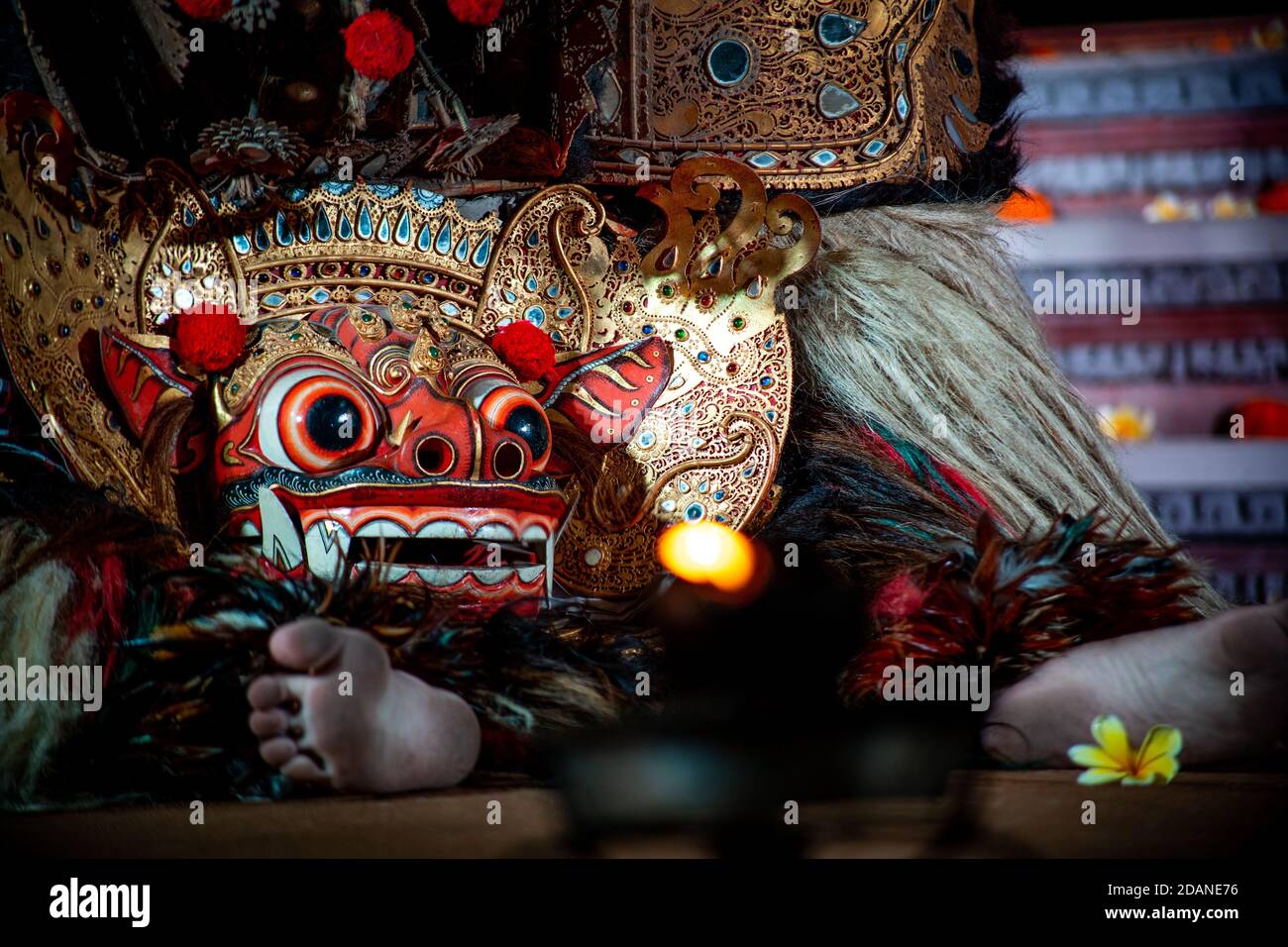 barong seduto sul pavimento con luce a candela Foto Stock