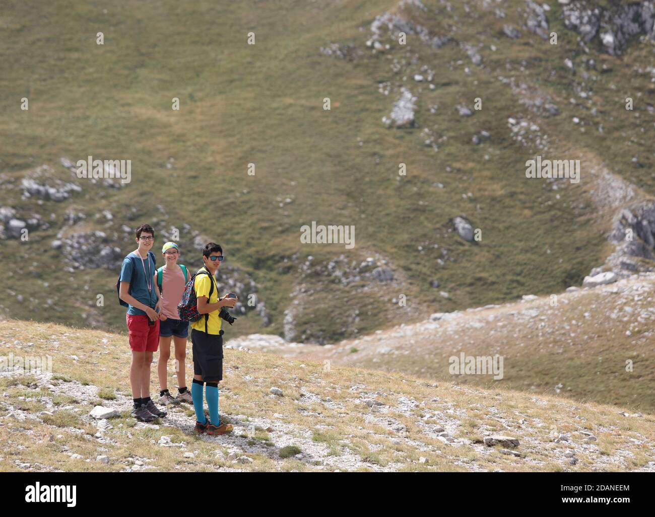 due fratelli e una giovane sorella in montagna durante una gita estiva Foto Stock