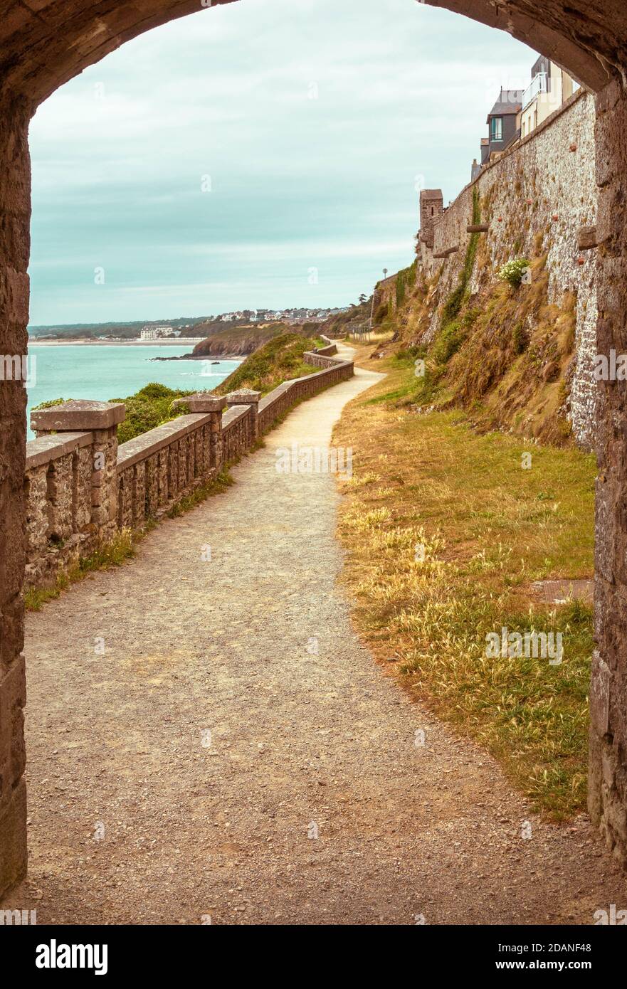Sentiero pedonale, sentiero attraverso la porta in pietra ad arco, su una spiaggia di Francia, paesaggio autunnale, Granville Foto Stock