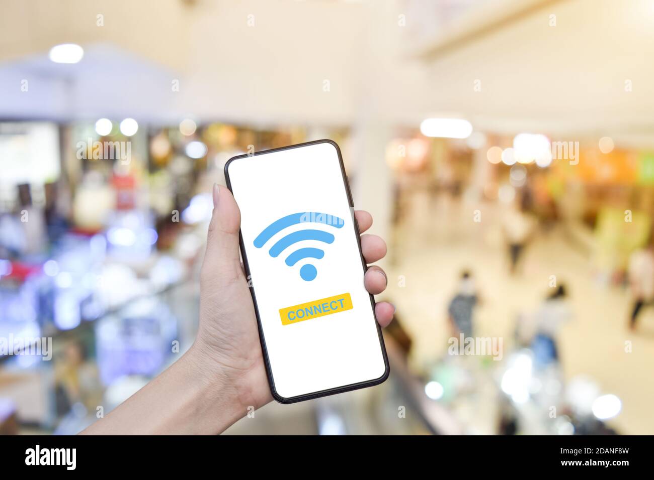 Primo piano dello smartphone portatile portatile con connessione wi-fi su sfondo sfocato del centro commerciale. Foto Stock