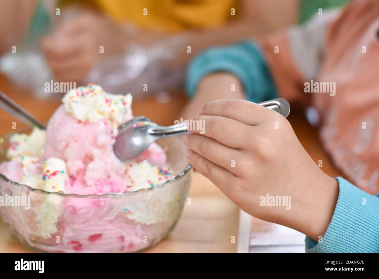 Primo piano di mani che tengono il cucchiaio mangiare gelato in tazza. Messa a fuoco selettiva Foto Stock