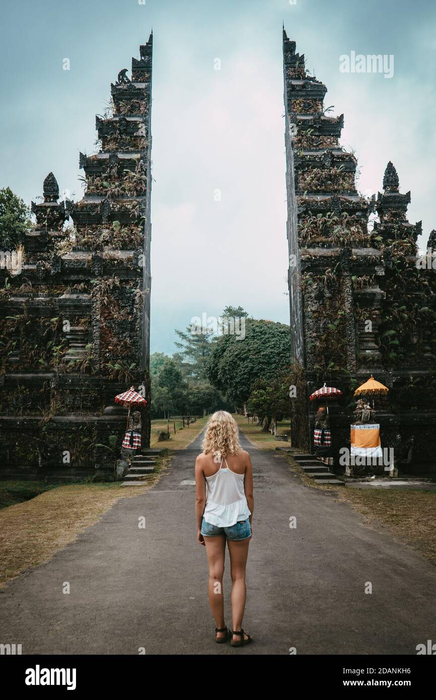 giovane donna in piedi davanti al cancello buddista con buio umore Foto Stock