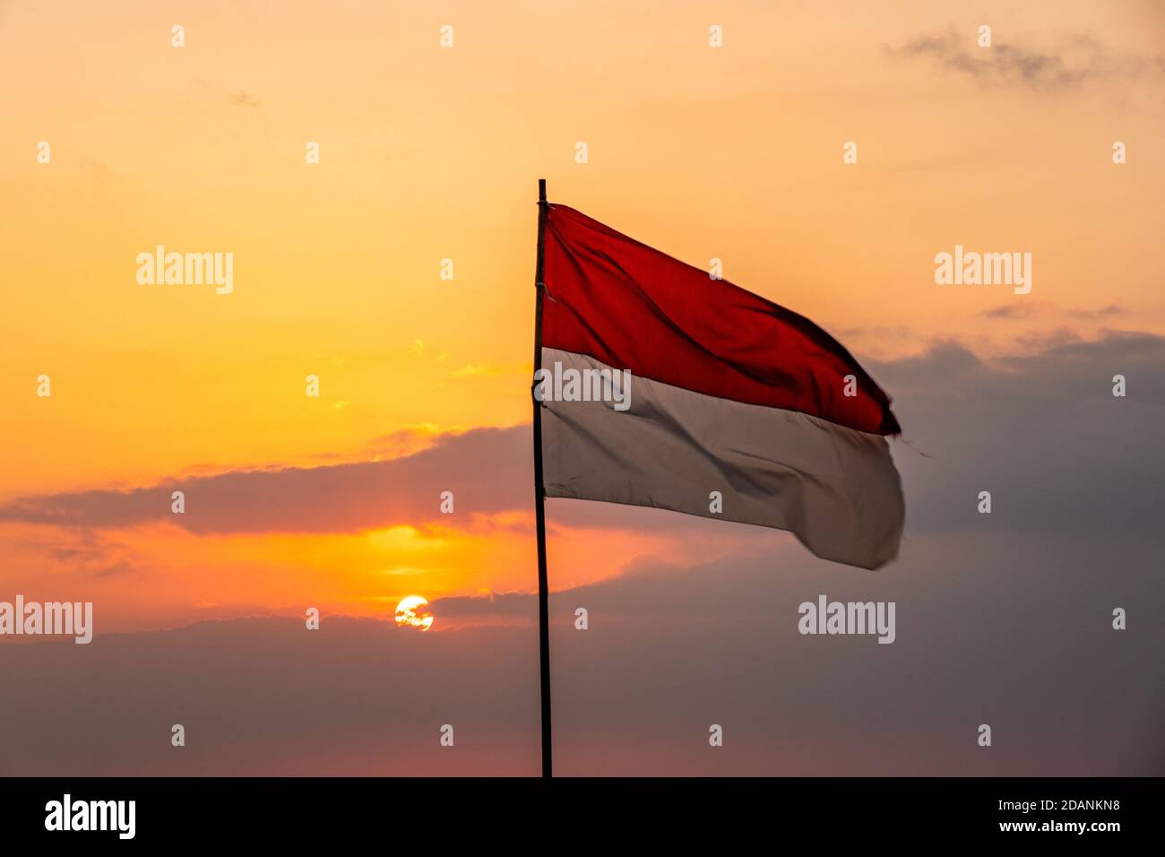 bandiera indonesiana che svanola al tramonto Foto Stock