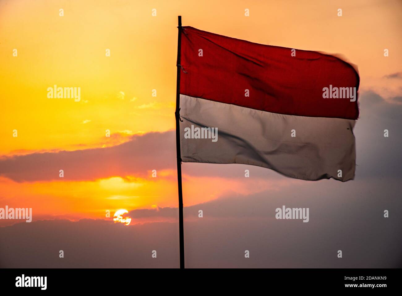 bandiera indonesiana che svanola al tramonto Foto Stock