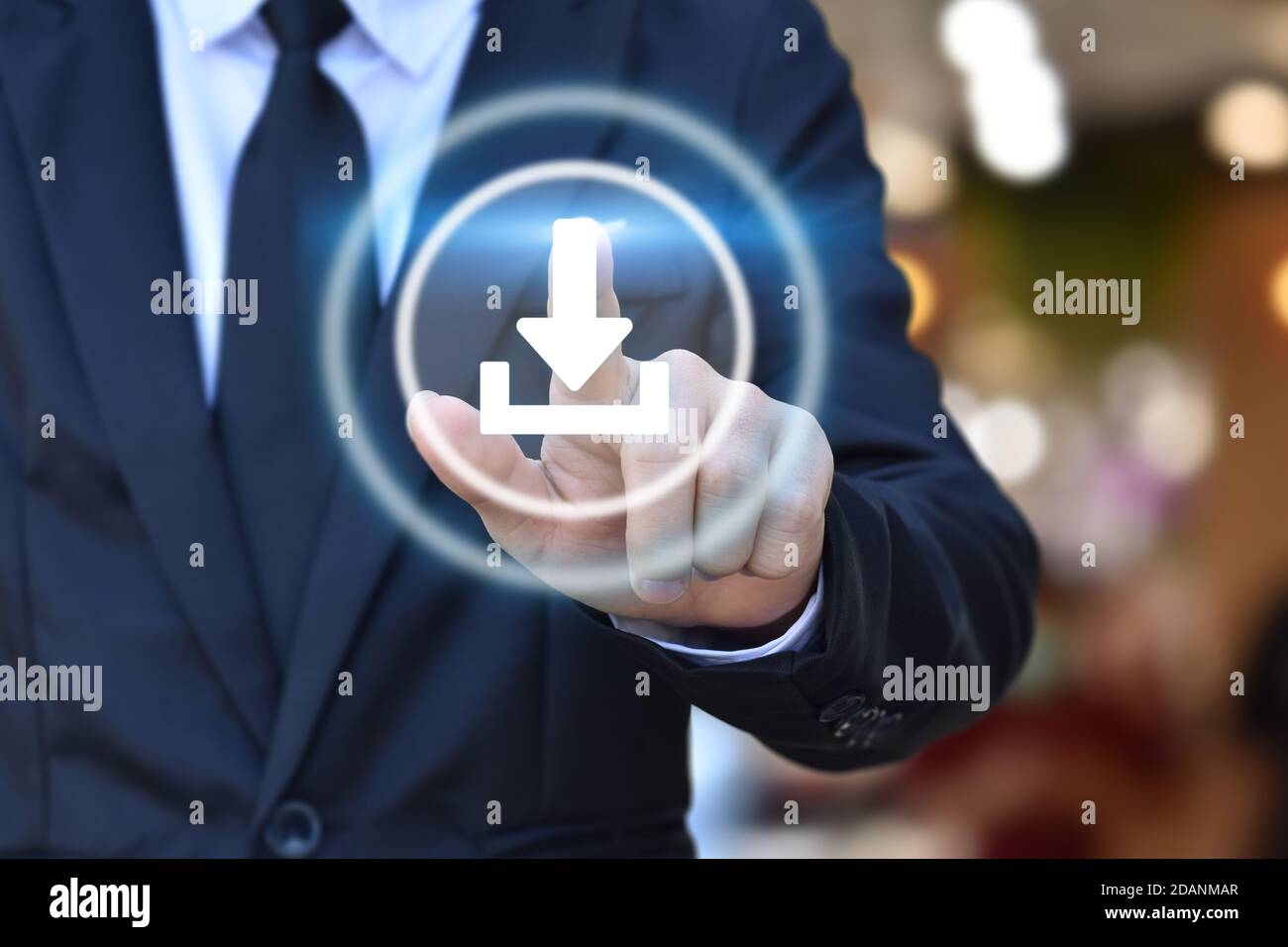 Mano di uomo d'affari che spinge l'icona del download sul touchscreen virtuale. Foto Stock