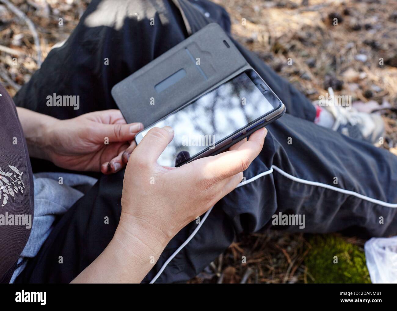 Primo piano delle mani delle donne che tengono il telefono cellulare all'aperto. Spazio di copia per il tuo SMS pubblicitario o contenuti promozionali Foto Stock