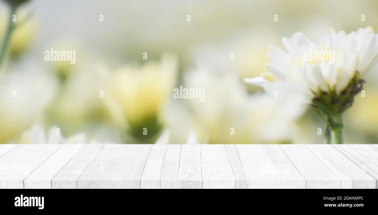 Tavolo vuoto in legno bianco con sfondo sfocato. Per la visualizzazione o il montaggio di pubblicità prodotto. Foto Stock