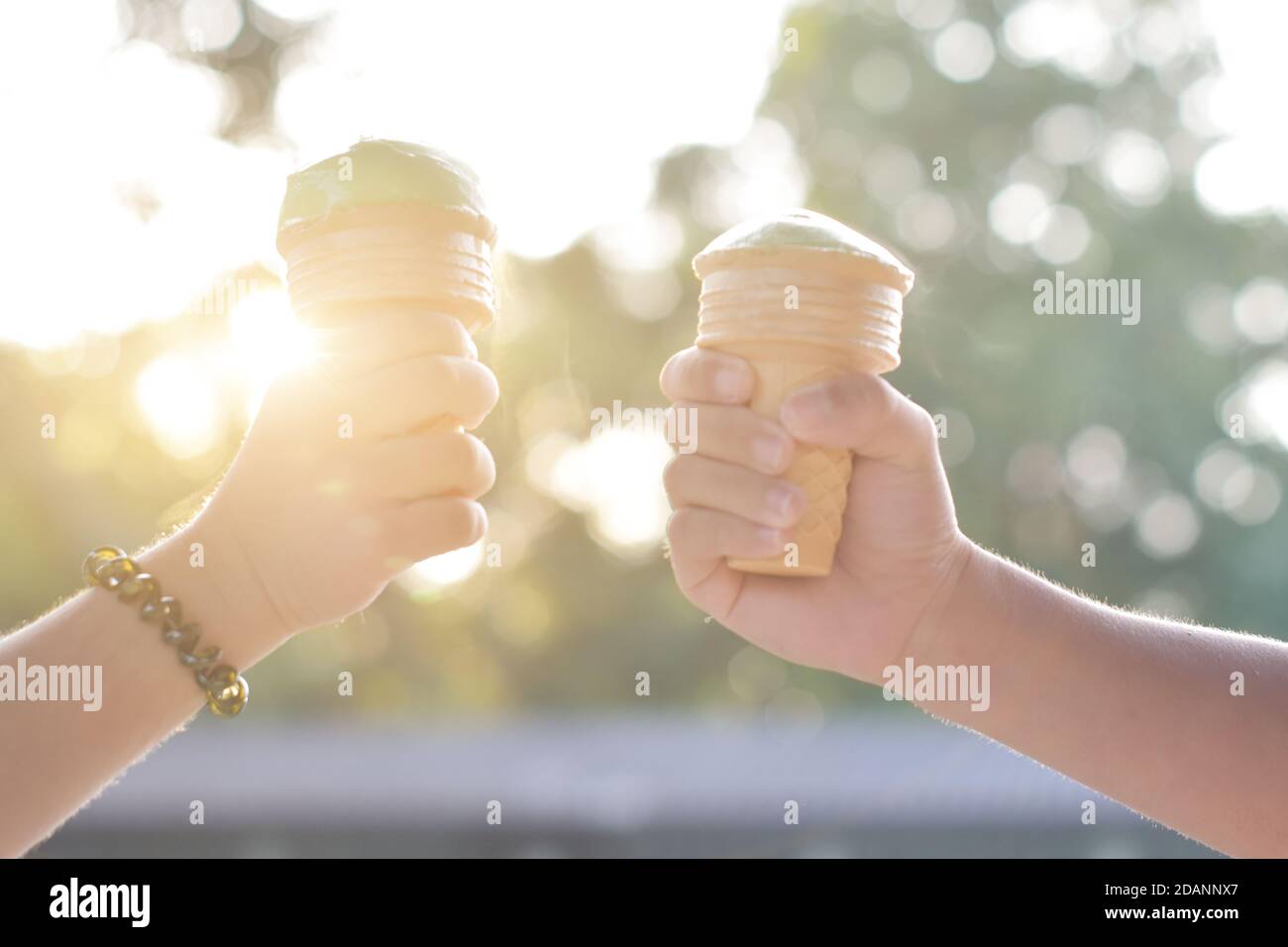 Due mani con cono gelato in estate in vacanza. Foto Stock