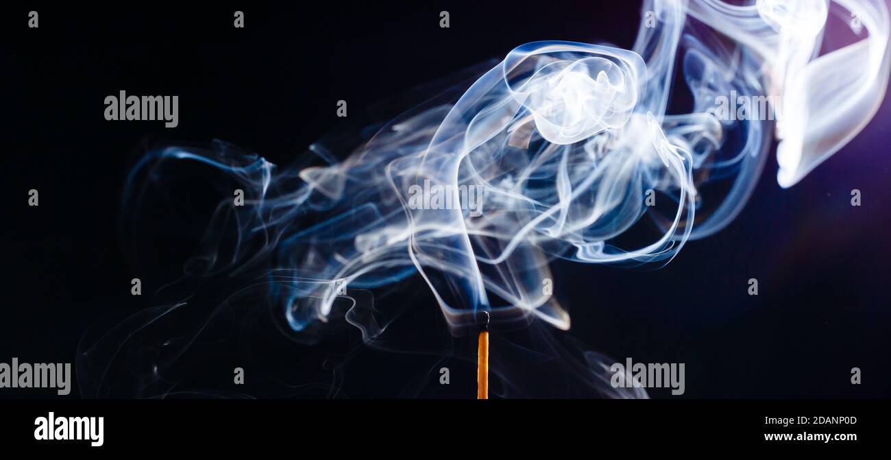 Fumo da una partita appena messo fuori, isolato su sfondo nero Foto Stock