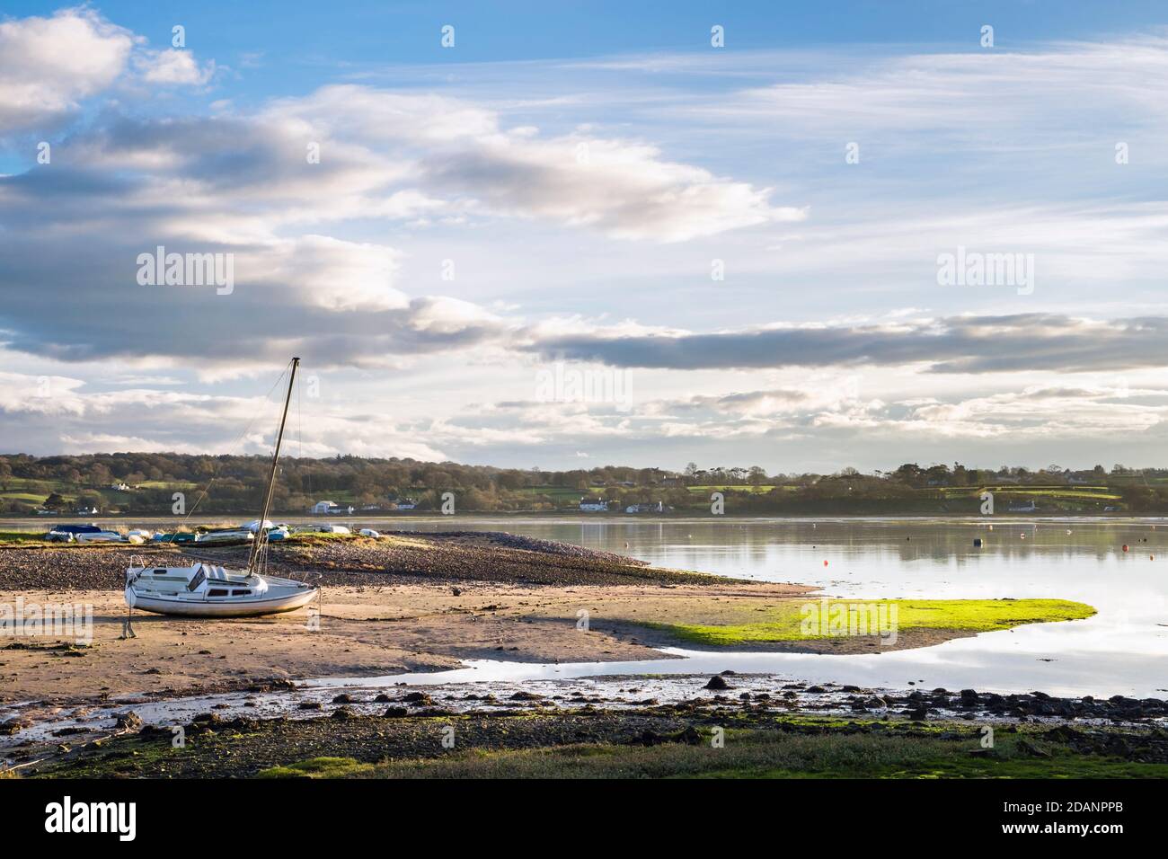 Barche a terra su banchi di sabbia con marea in arrivo nel porto di Red Wharf Bay, Isola di Anglesey, Galles, Regno Unito, Gran Bretagna Foto Stock