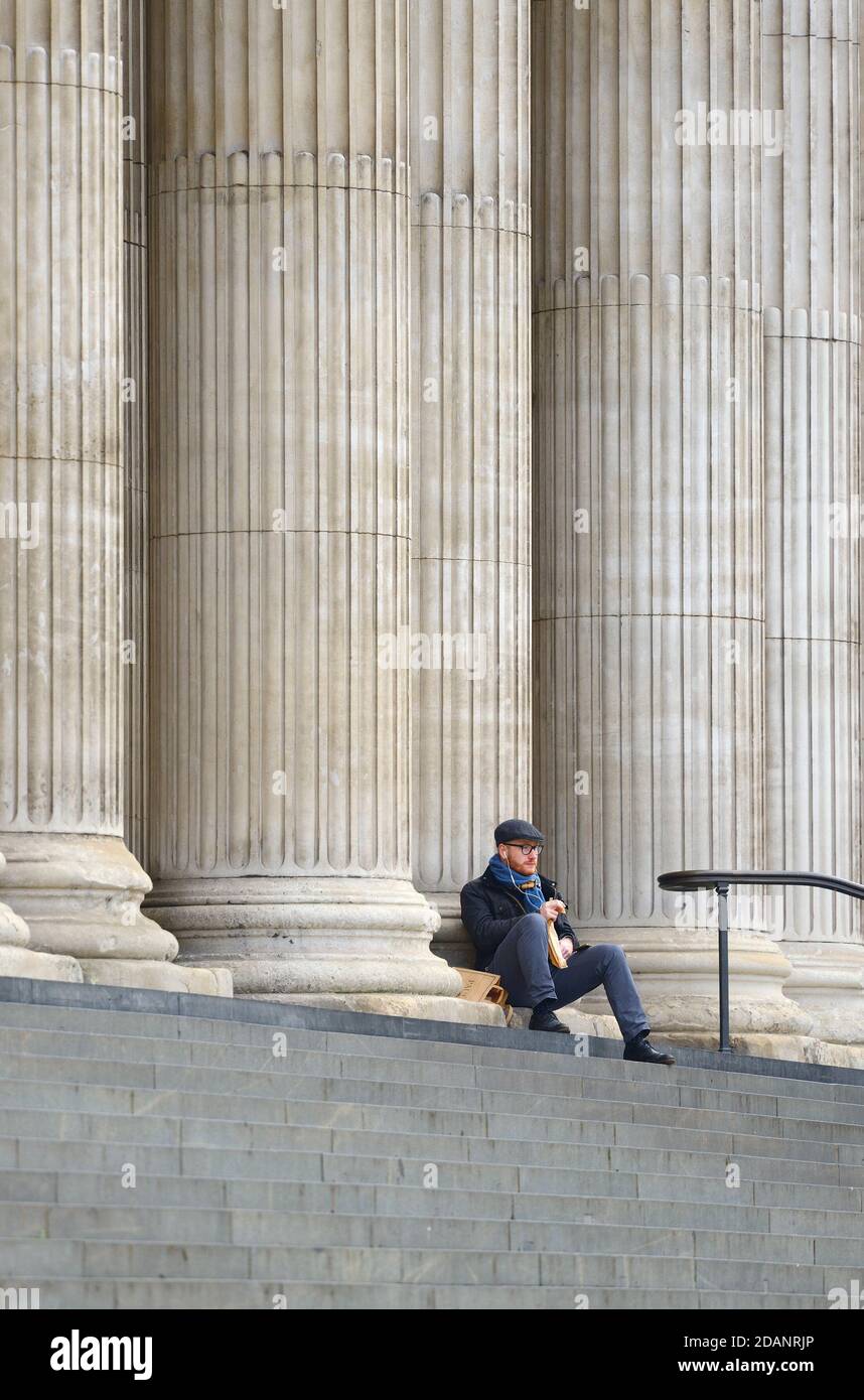 Londra, Inghilterra, Regno Unito. Uomo che mangia il suo pranzo sui gradini della Cattedrale di San Paolo curando il secondo blocco COVID, novembre 2020. Foto Stock