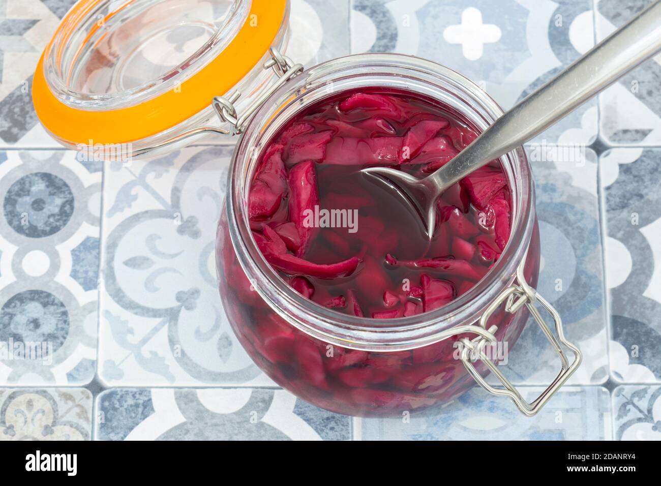 Cavolo rosso decapato in un vasetto di conservazione in vetro a clip. Su uno sfondo blu Foto Stock