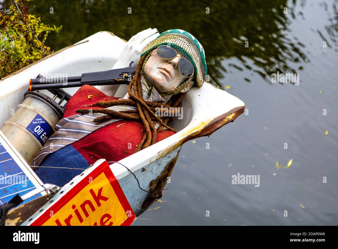 Un nammequin con occhiali da sole in una vasca da bagno, decorazione di una casalinga lungo il Canal Grand Union in Colne Valley, Uxbridge, Regno Unito Foto Stock