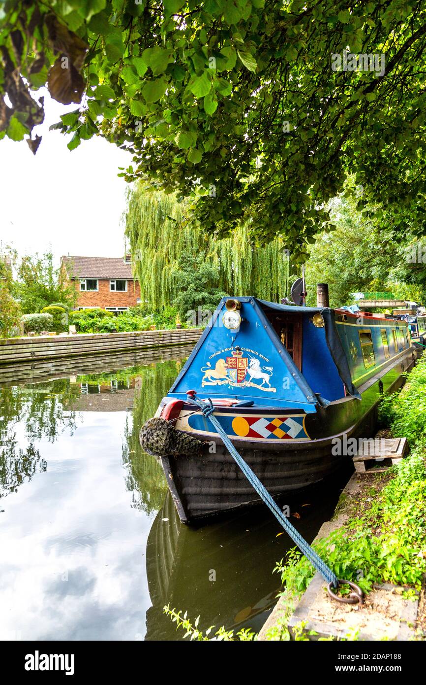 Blue houseboat decorata in rose popolari e castelli in stile ormeggio sul Canal Grand Union, Colne Valley, Rickmansworth, Regno Unito Foto Stock