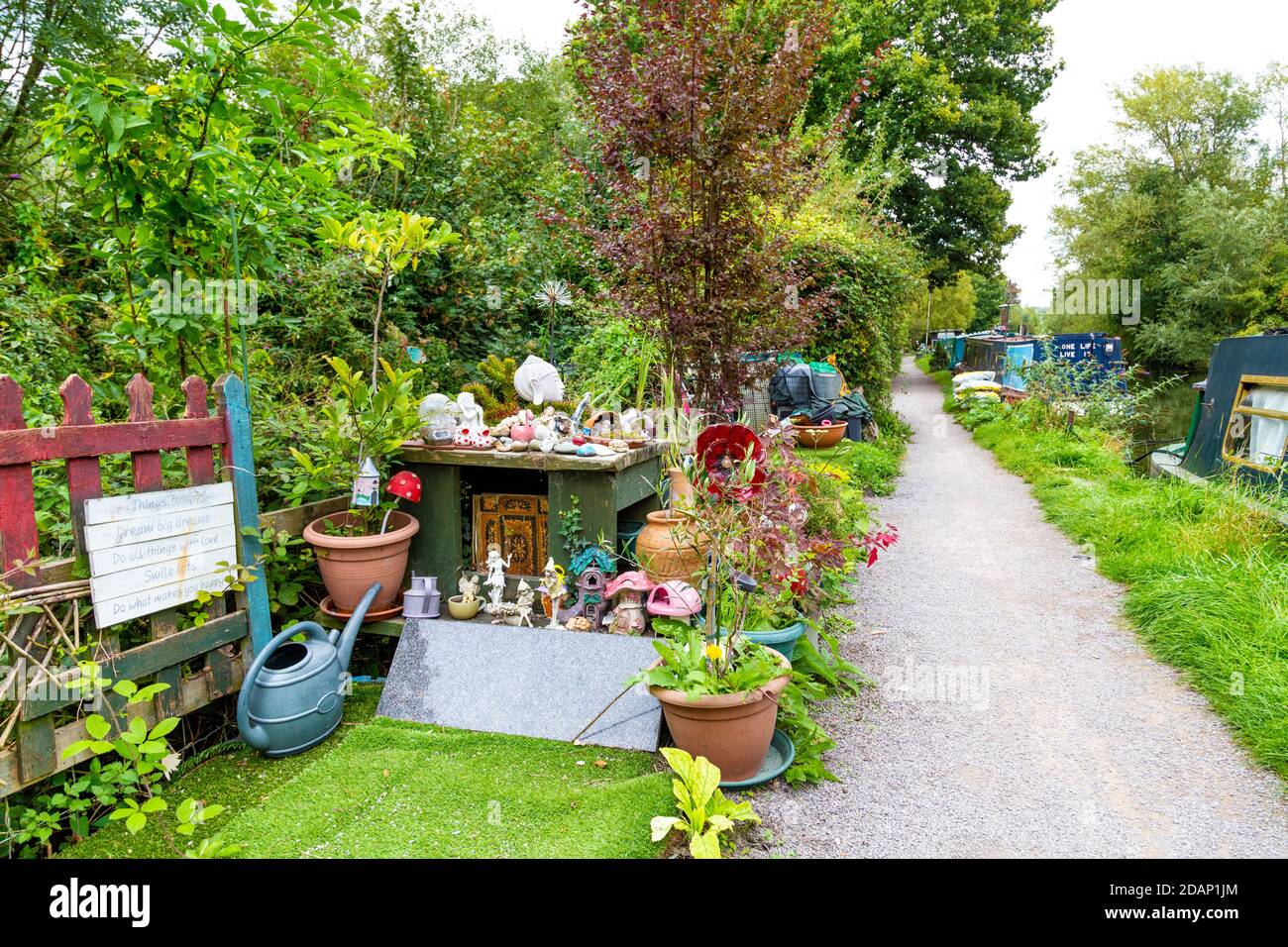 Un giardino insolito riccamente decorato di un proprietario di una casa galleggiante lungo il Canal Grand Union, Colne Valley, Regno Unito Foto Stock
