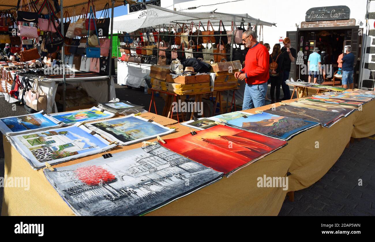 Commerciante di mercato che vende la pittura nel mercato di Teguise. Foto Stock