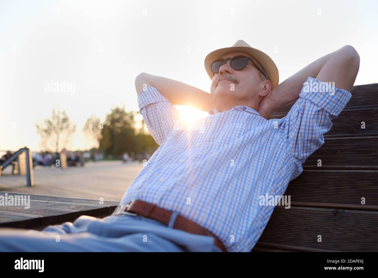 Uomo anziano in occhiali da sole che si rilassa in un parco Foto Stock