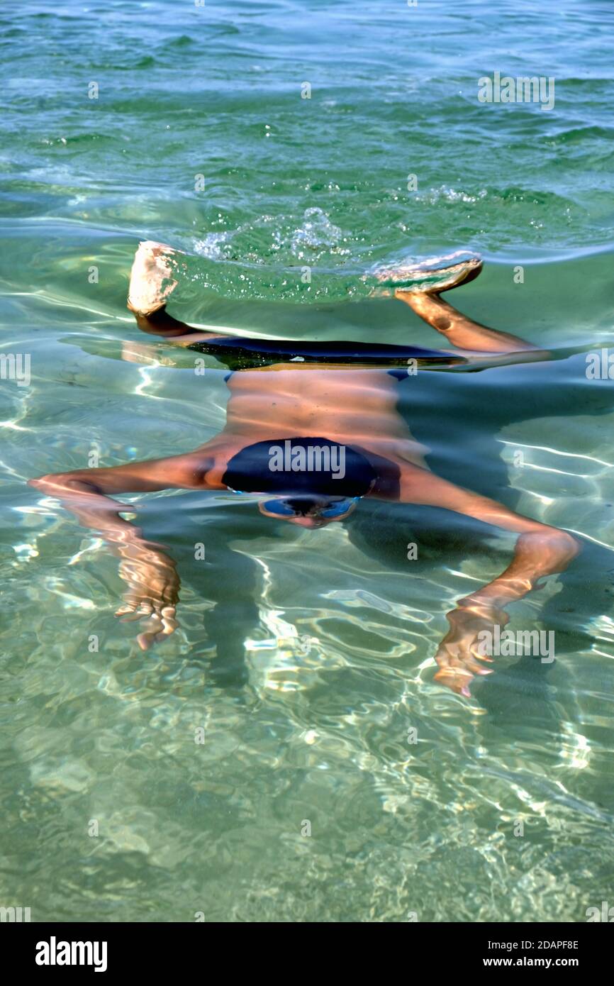 il ragazzo nuota in apnea in acque limpide Foto Stock