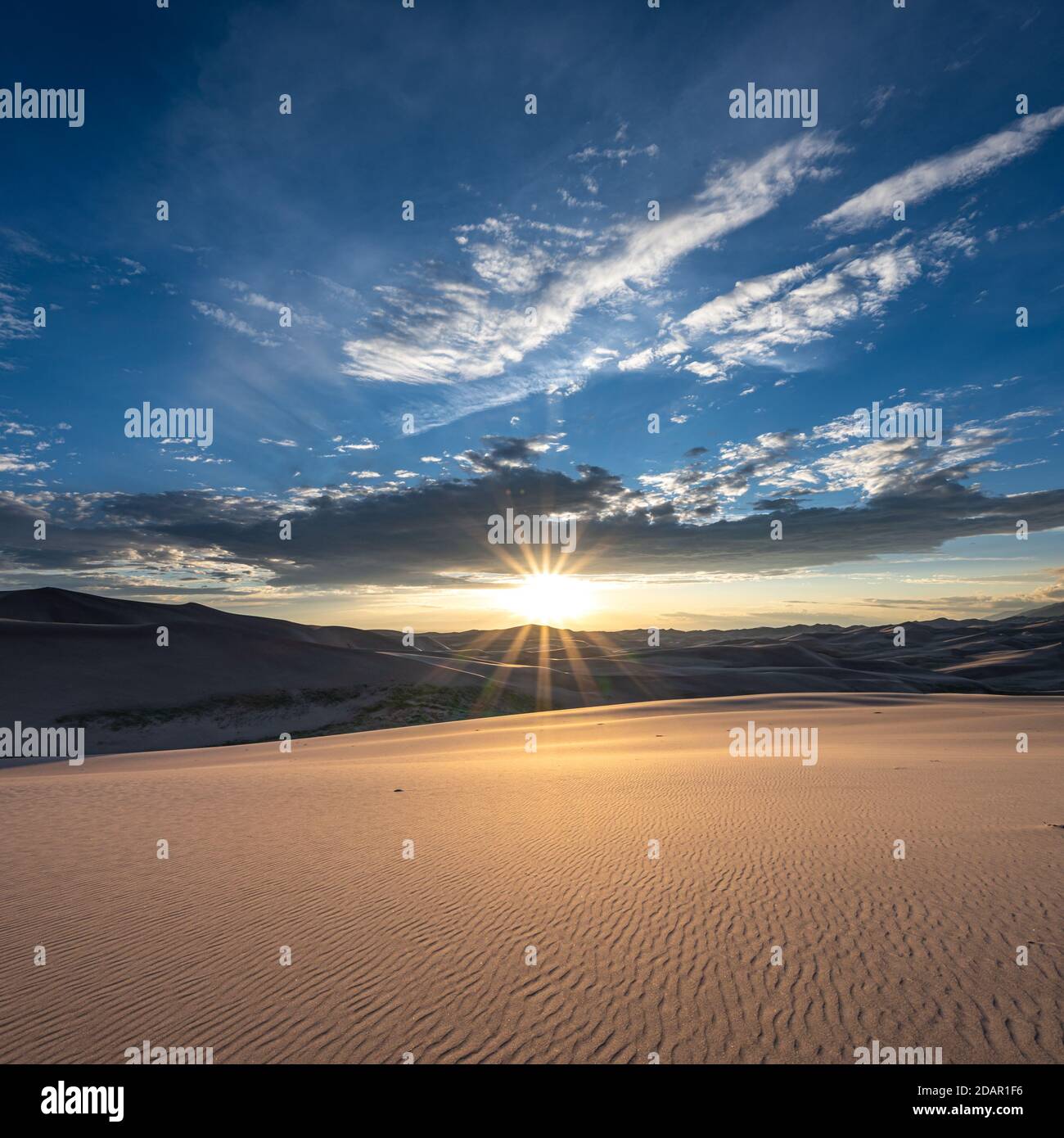 Sand Dunes Ripple sotto Sun Burst dal tramonto Foto Stock