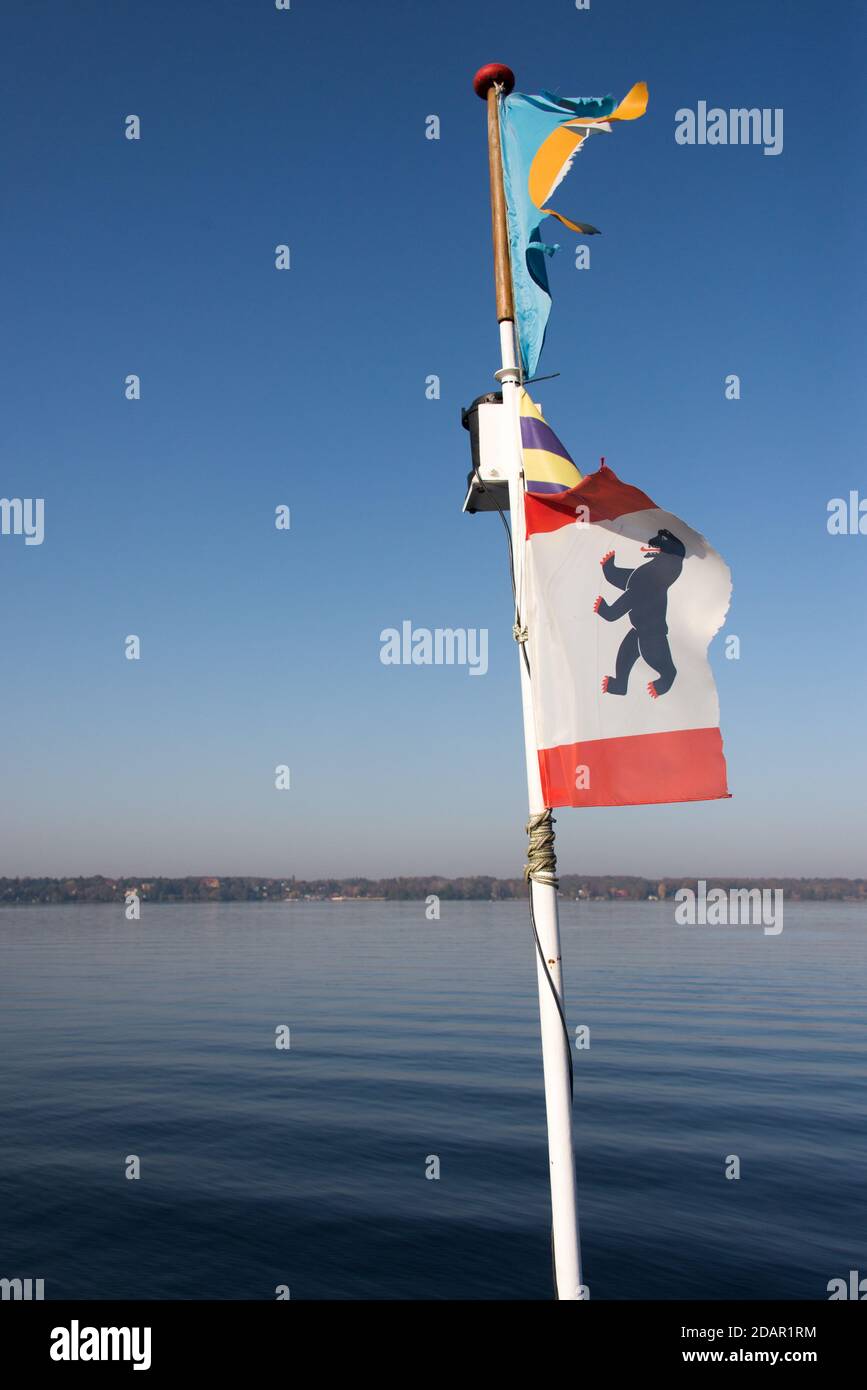 Battute bandiere su un traghetto nelle tranquille ore mattutine in autunno al lago Wannsee a Berlino Foto Stock