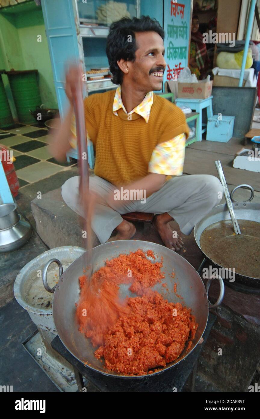 Cibo di strada e un sorriso nel mercato di Udaipur, India Foto Stock
