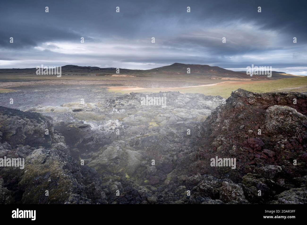 Lava nera solidificata in pianura verde con vapore, Leihrnjukur nel Krafla, campo di lava di Krafla, Skutustaoir, Norourland eystra, Islanda Foto Stock