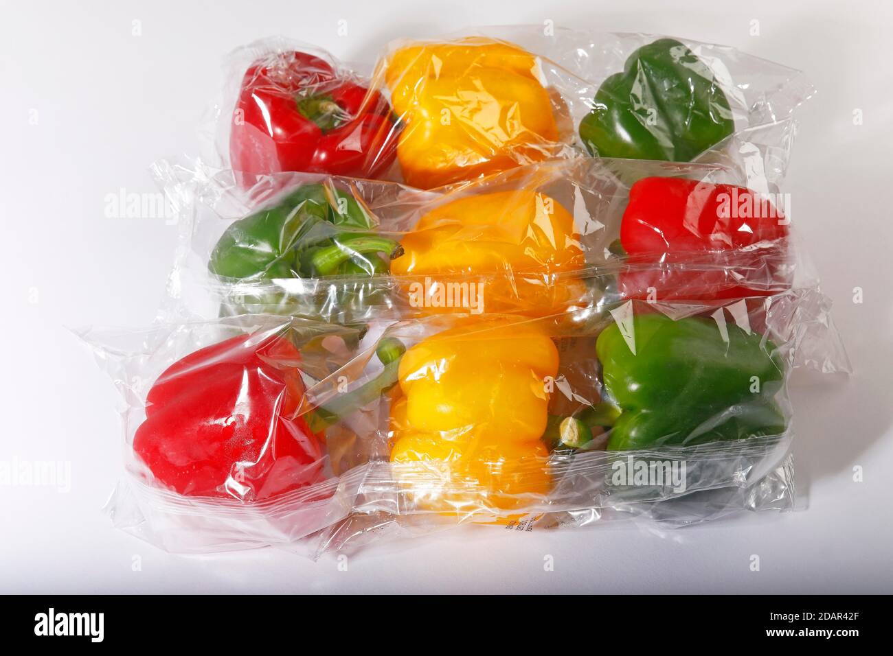 Rosso, giallo e i peperoni verdi (Capsicum annuum) dal supermercato avvolti in una pellicola termocontrattile in plastica, verdure in un imballaggio plastico, rifiuti in plastica Foto Stock