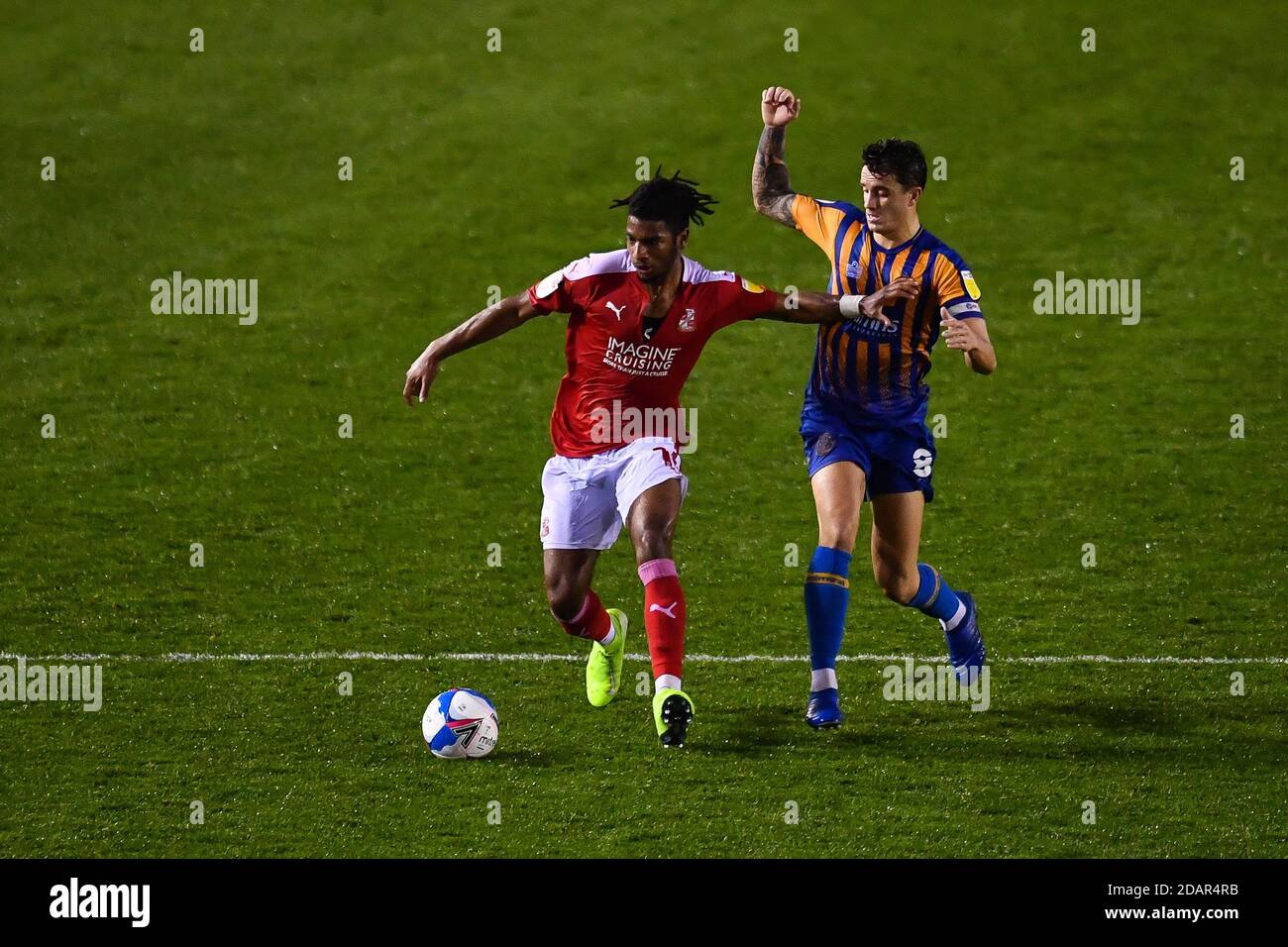 Akinwale Odimayo n. 16 della città di Swindon tiene fuori Oliver Norburn 8 di Shrewsbury Town Foto Stock