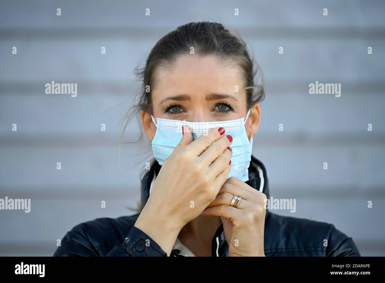 Donna mette su una maschera facciale, la muove, ritratto, crisi corona, Stoccarda, Baden-Wuerttemberg, Germania Foto Stock